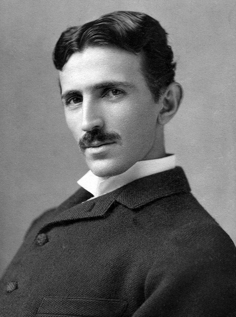 Black and white photograph of Nikola Tesla, about 1890, in a dark suit